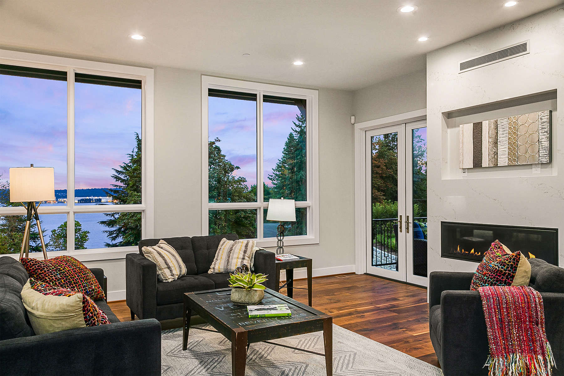 Living room with large windows, a fireplace and wood flooring